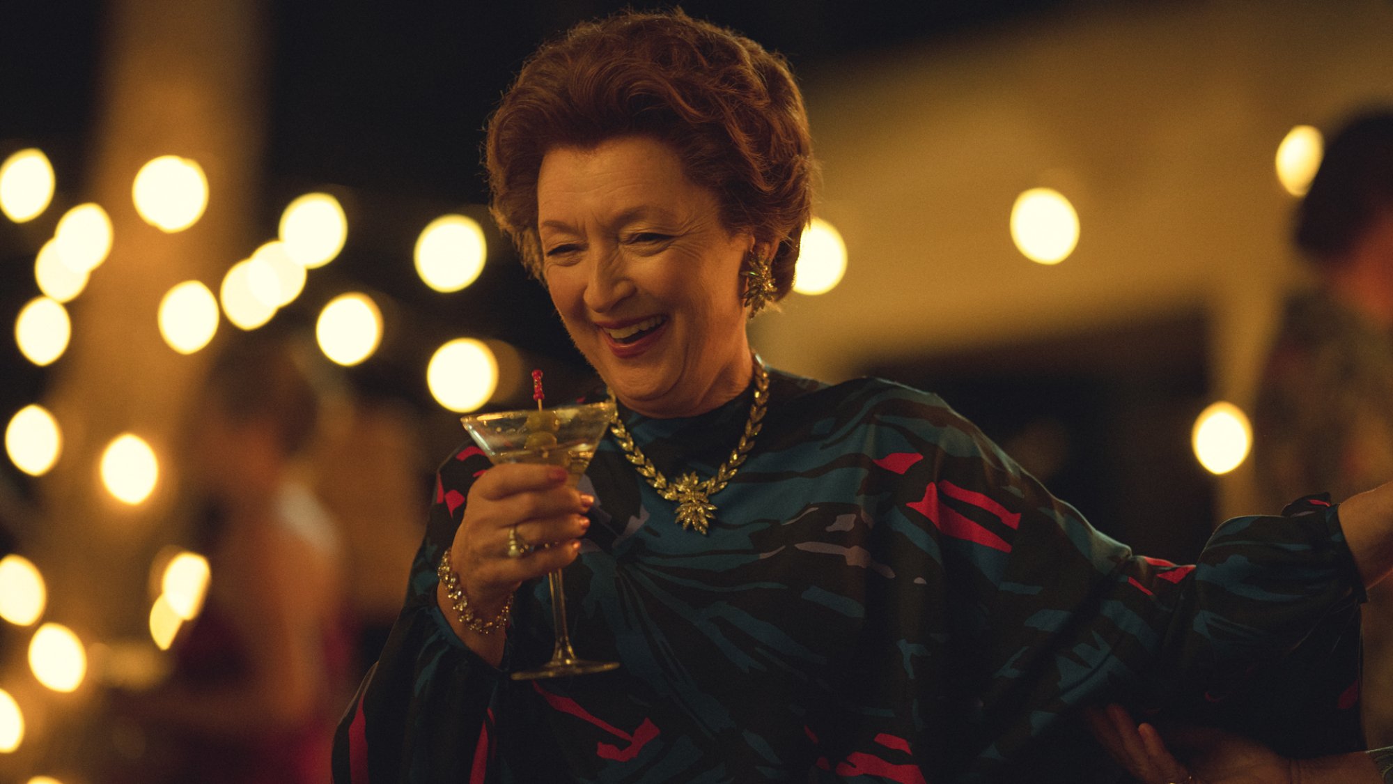 Lesley Manville as Princess Margaret drinking a cocktail at a party.