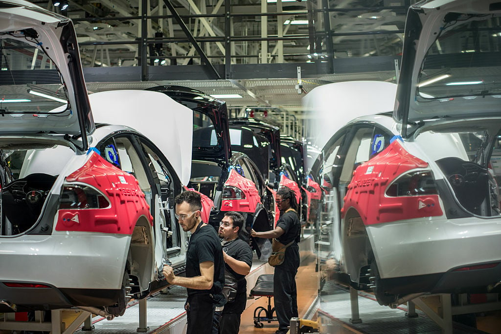 Workers assemble cars on the line at Tesla's factory in Fremont.