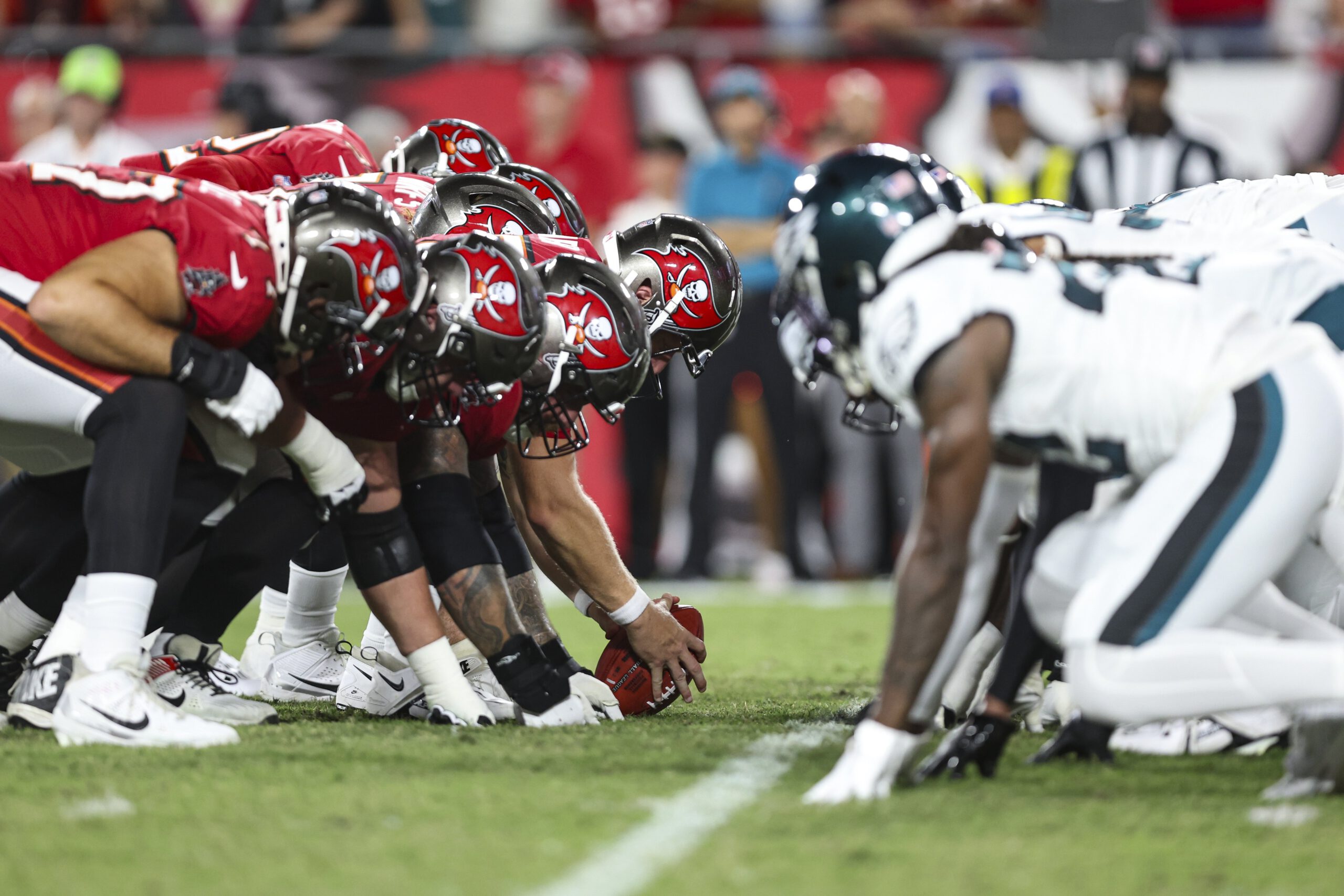 Eagles players line up on the field against the Buccaneers players.