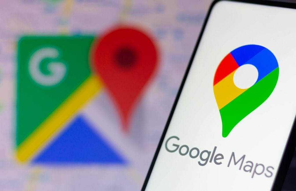 The Google Maps logo seen displayed on a smartphone and in the background.