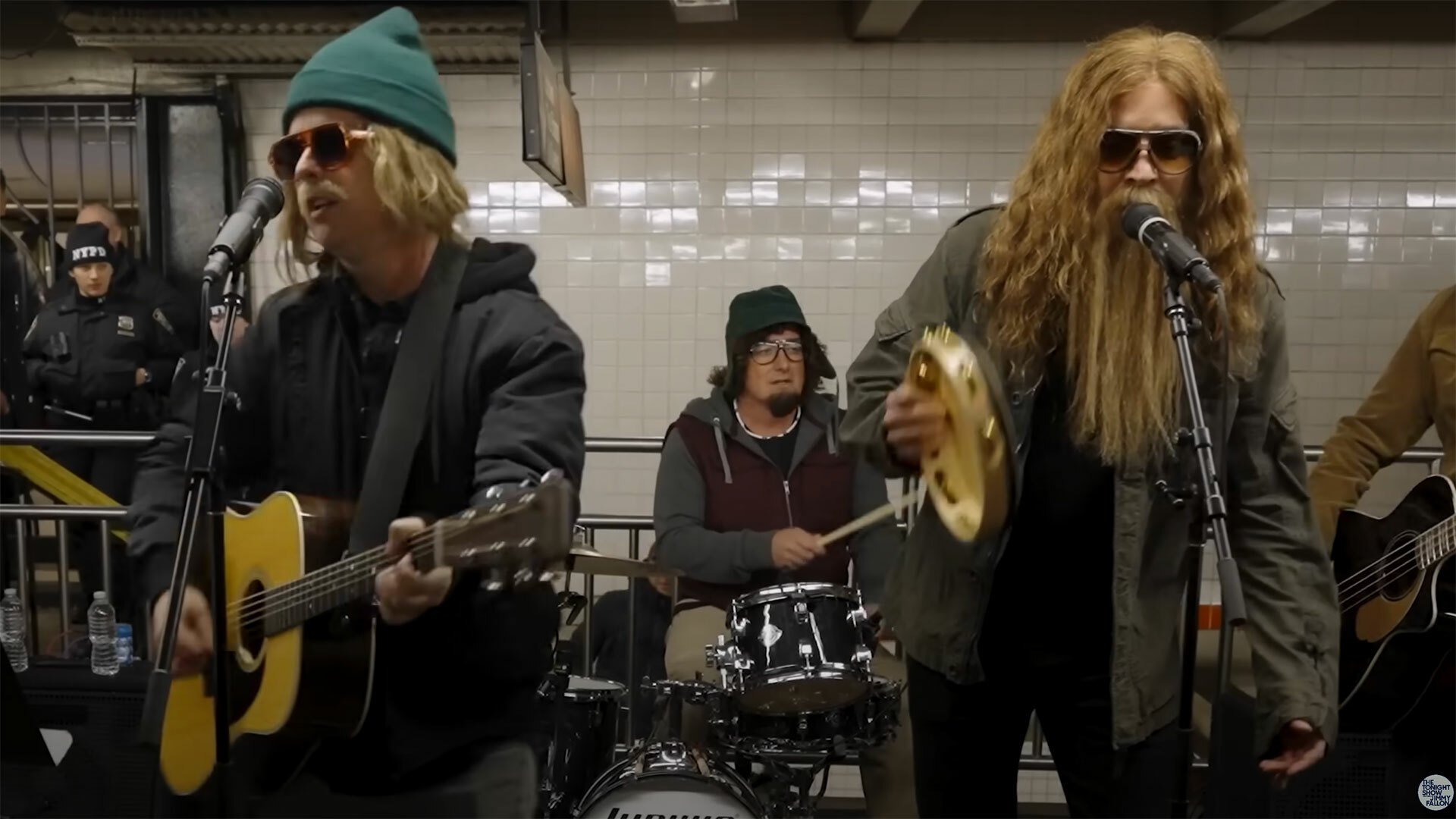 A group of buskers with beards and sunglasses play on the subway.