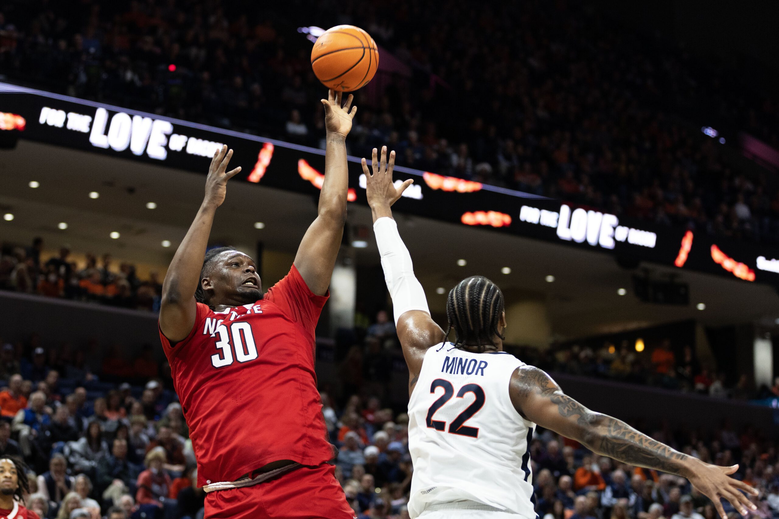 DJ Burns, Jr. of the NC State Wolfpack shoots over Jordan Minor of the Virginia Cavaliers in the first half during a game at John Paul Jones Arena on January 24, 2024, in Charlottesville, Virginia.