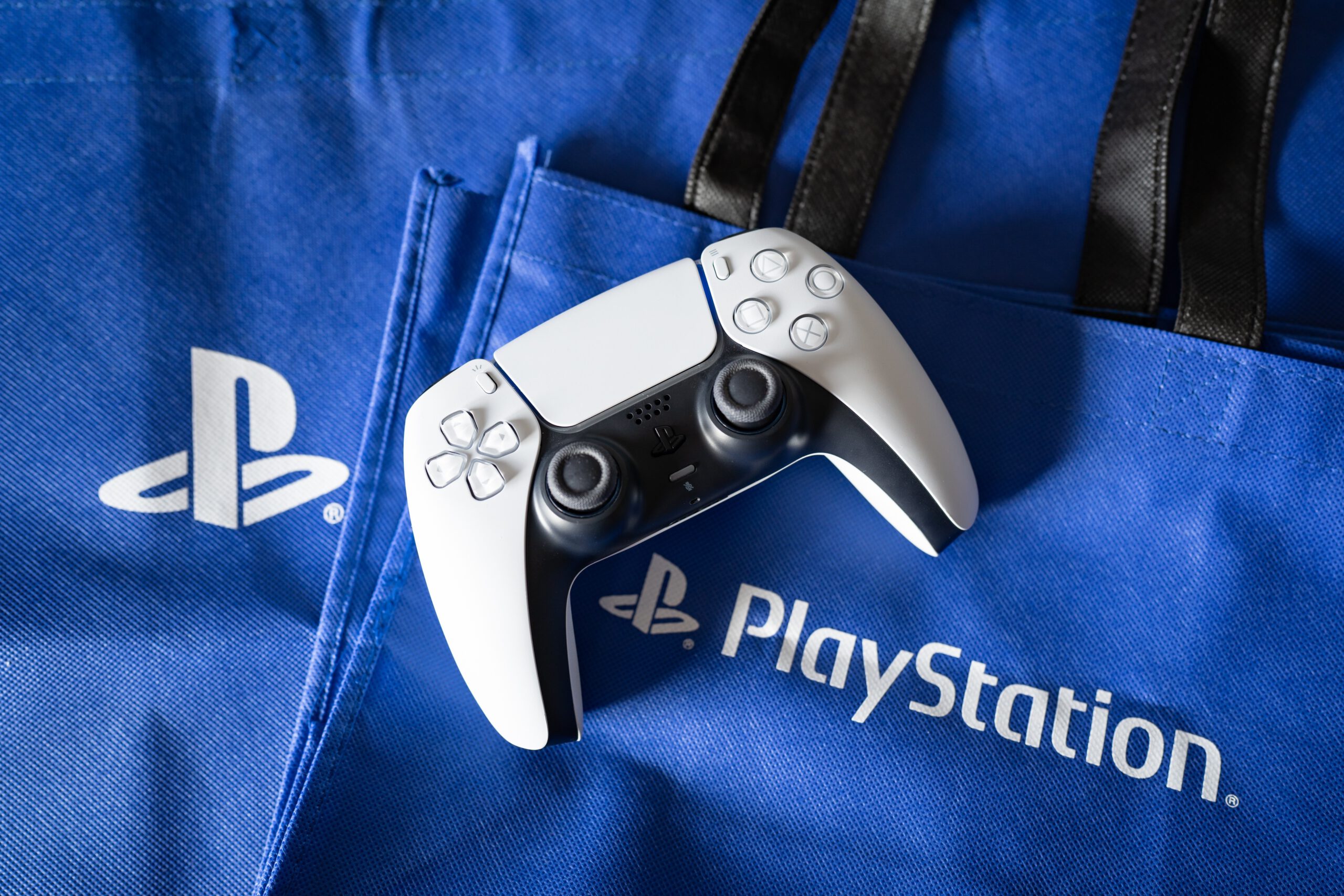 Playstation 5's DualSense game controller and Playstation logo.