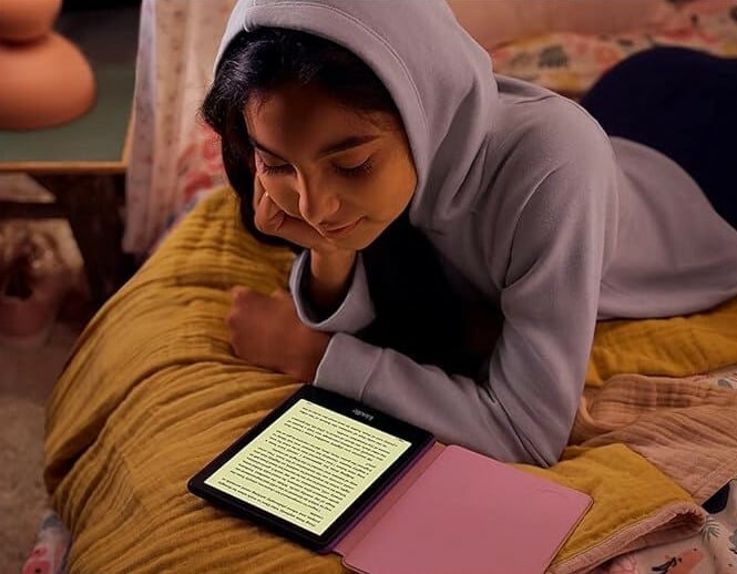 A girl reads from a Kindle Paperwhite Kids