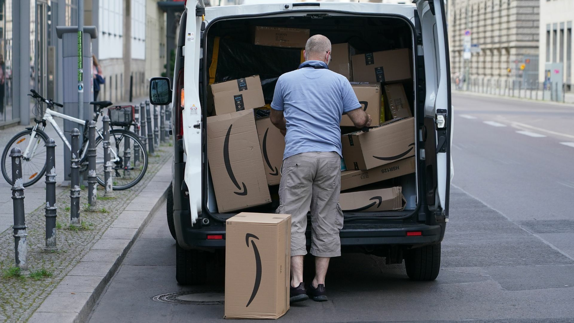 A courier unloads Amazon packages during a delivery.