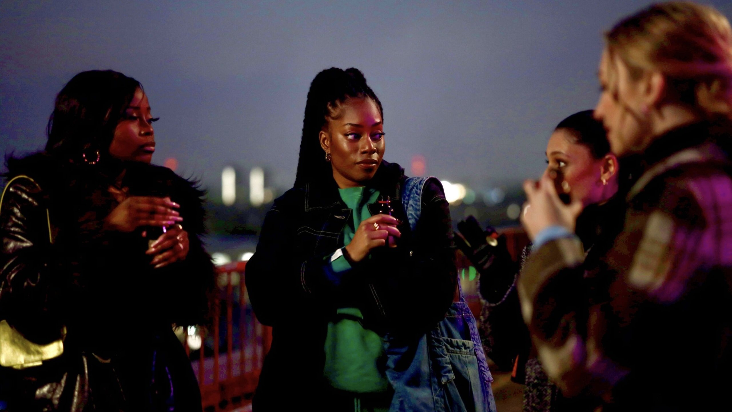 Four young woman at a rooftop party.