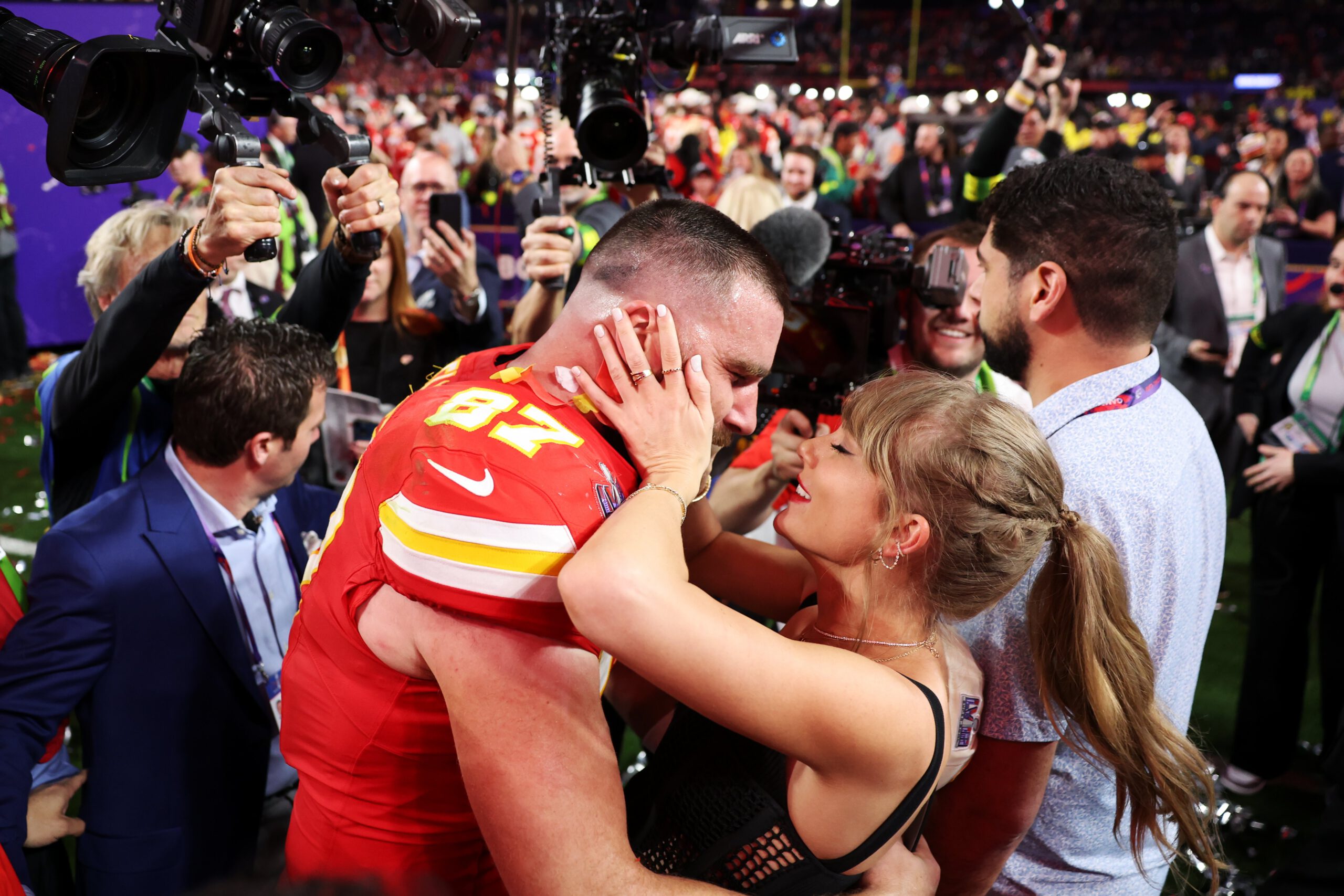 Travis Kelce and Taylor Swift celebrating on the field after the Super Bowl.