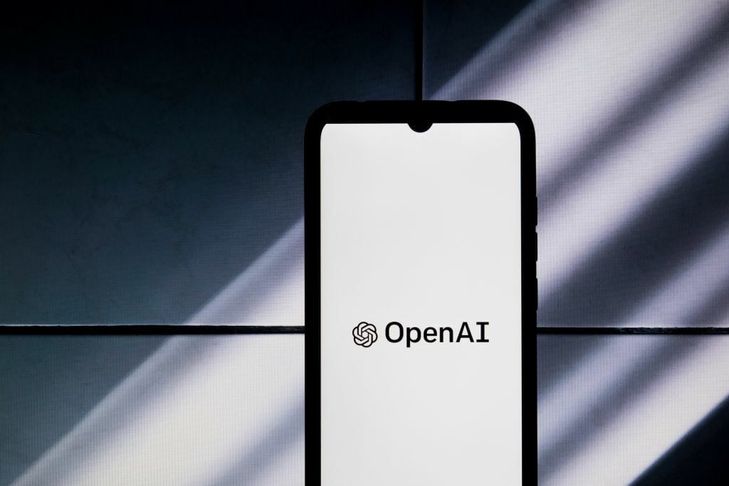 OpenAI logo on a smartphone against a gray backdrop