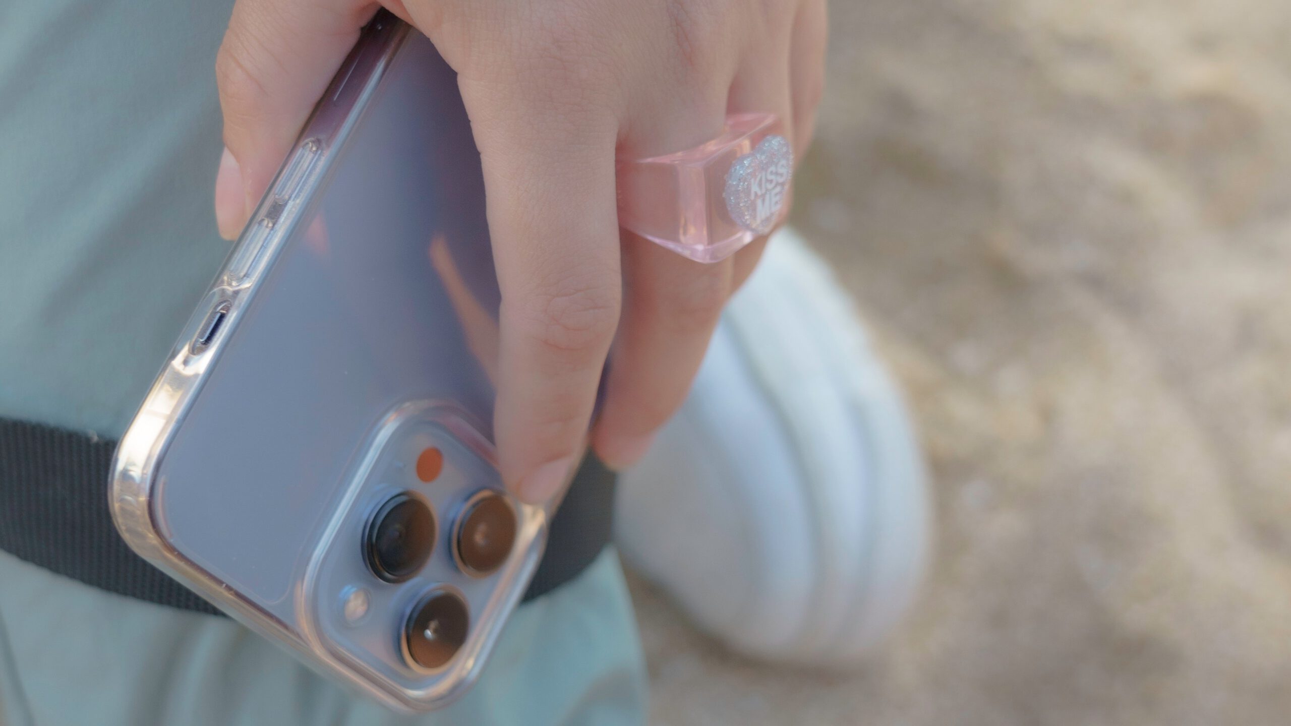 A person with a ring holding an iPhone