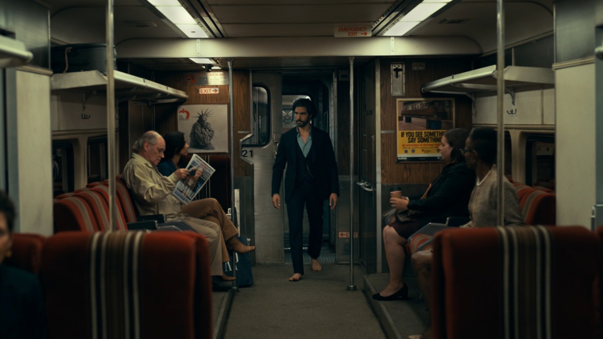 A man stands in a subway train car.