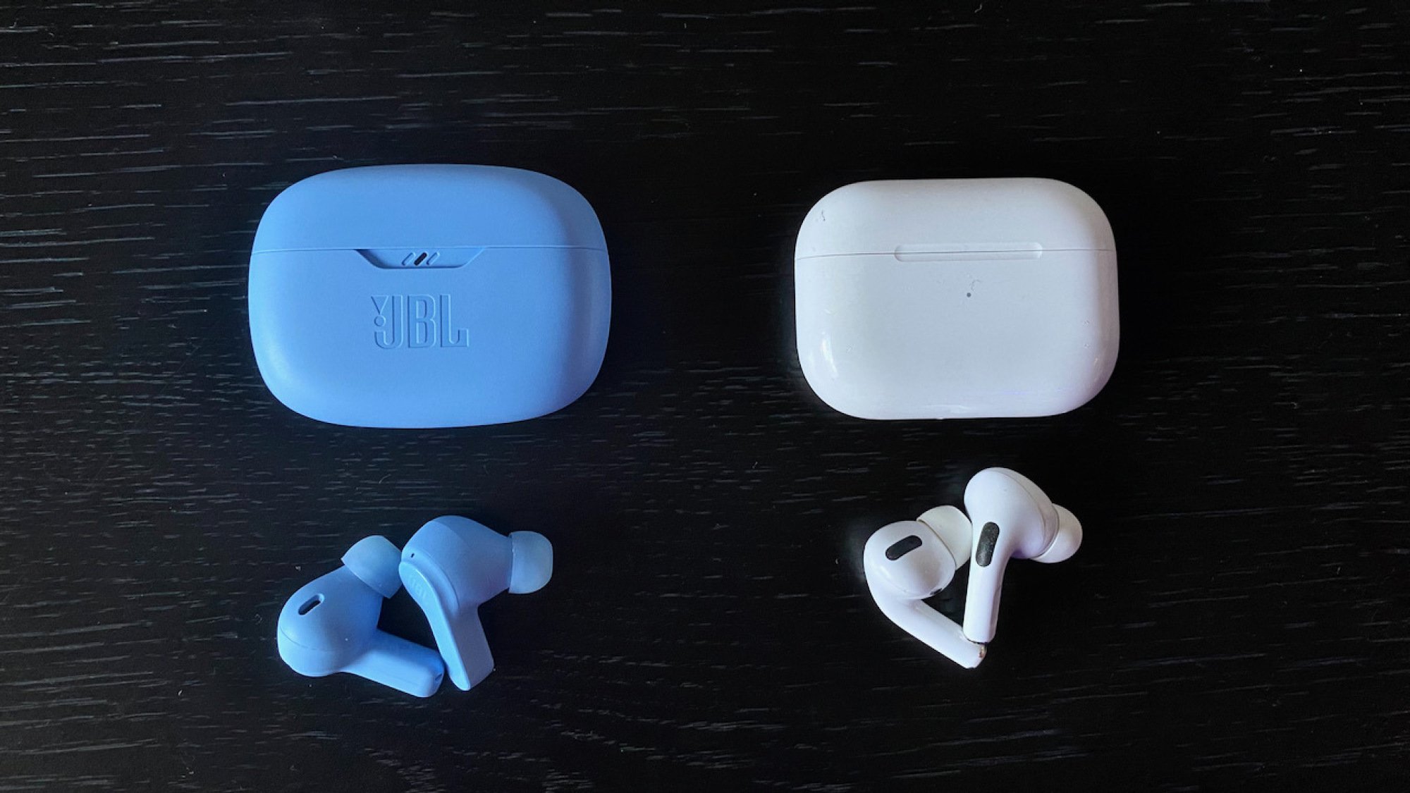 JBL vibe beam earbuds next to Apple AirPods Pro
