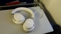 bose quietcomfort ultra headphones on airplane seat back tray