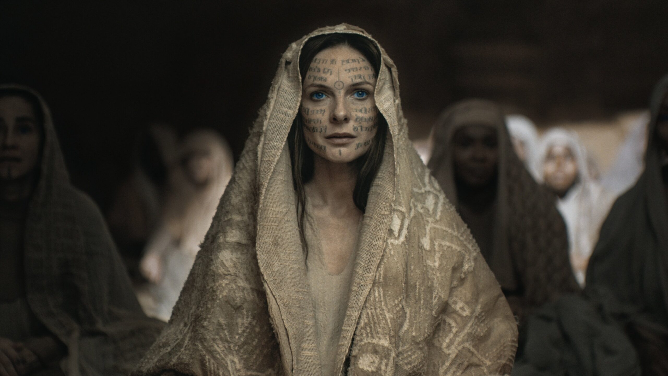 Lady Jessica sitting among Fremen women in Sietch Tabr.
