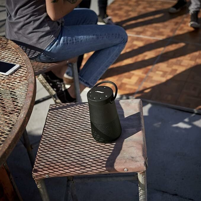 The Bose SoundLink Revolve+ sits on an outdoor patio table. 