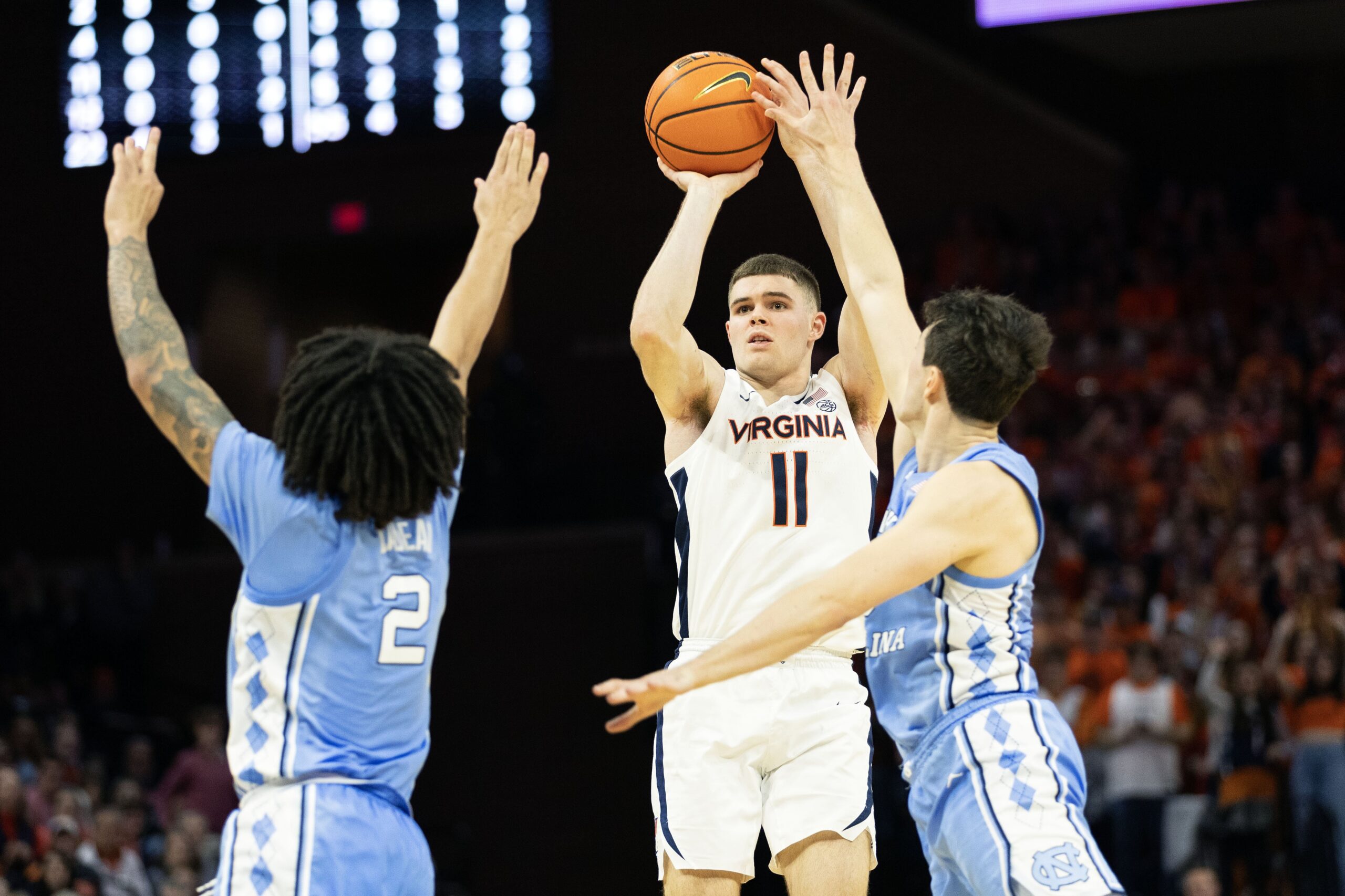 Isaac McKneely #11 of the Virginia Cavaliers men’s basketball team shoots between Elliot Cadeau #2 and Cormac Ryan #3 of the North Carolina Tar Heels in the second half during a game at John Paul Jones Arena on February 24, 2024, in Charlottesville, Virginia.