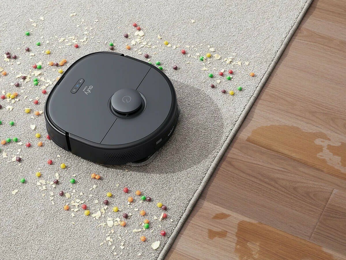 Eufy X9 Pro robot vacuum cleaning candy off of rug after mopping hardwood floor