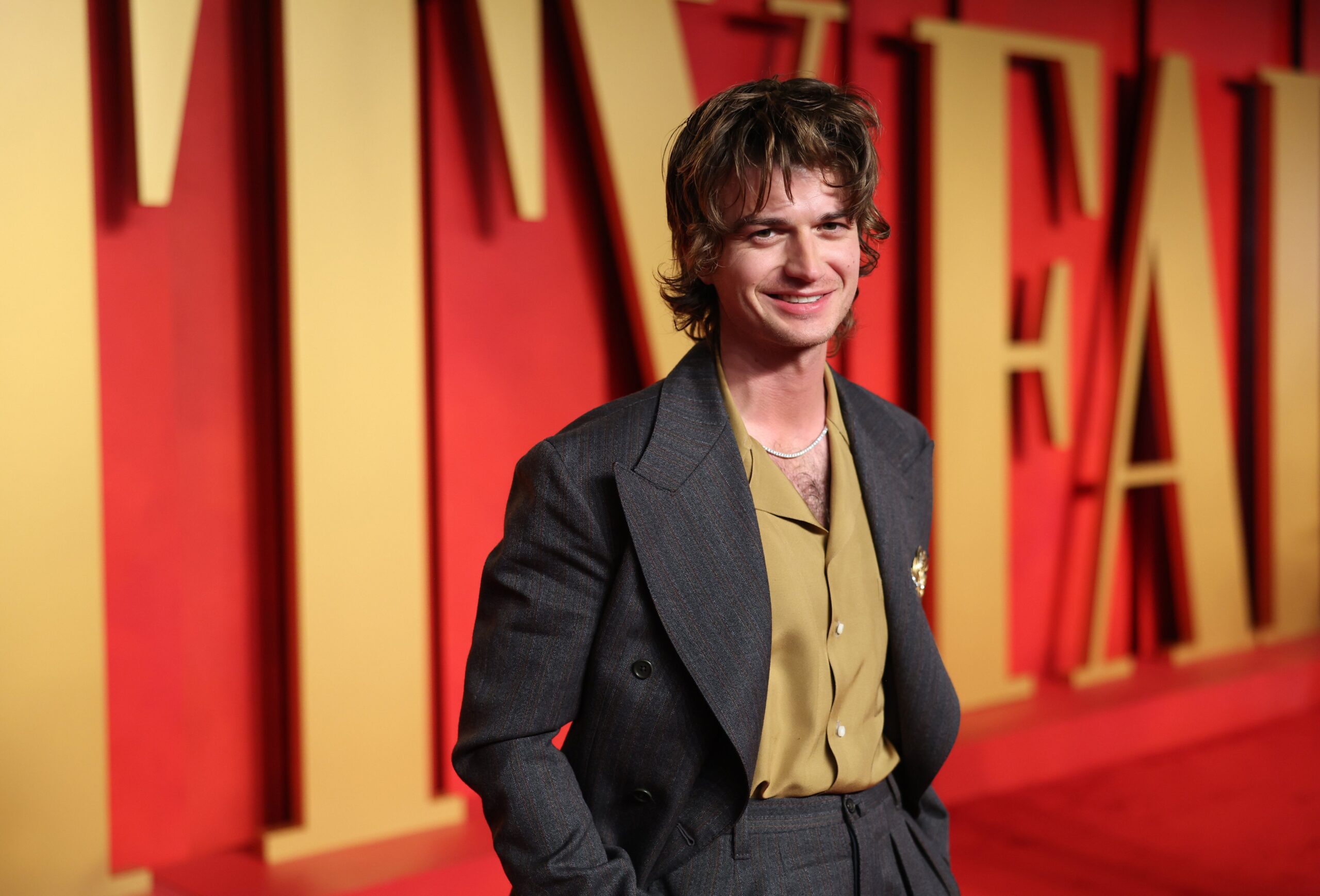 Joe Keery smiling on the red carpet of Vanity Fair Oscars after party.