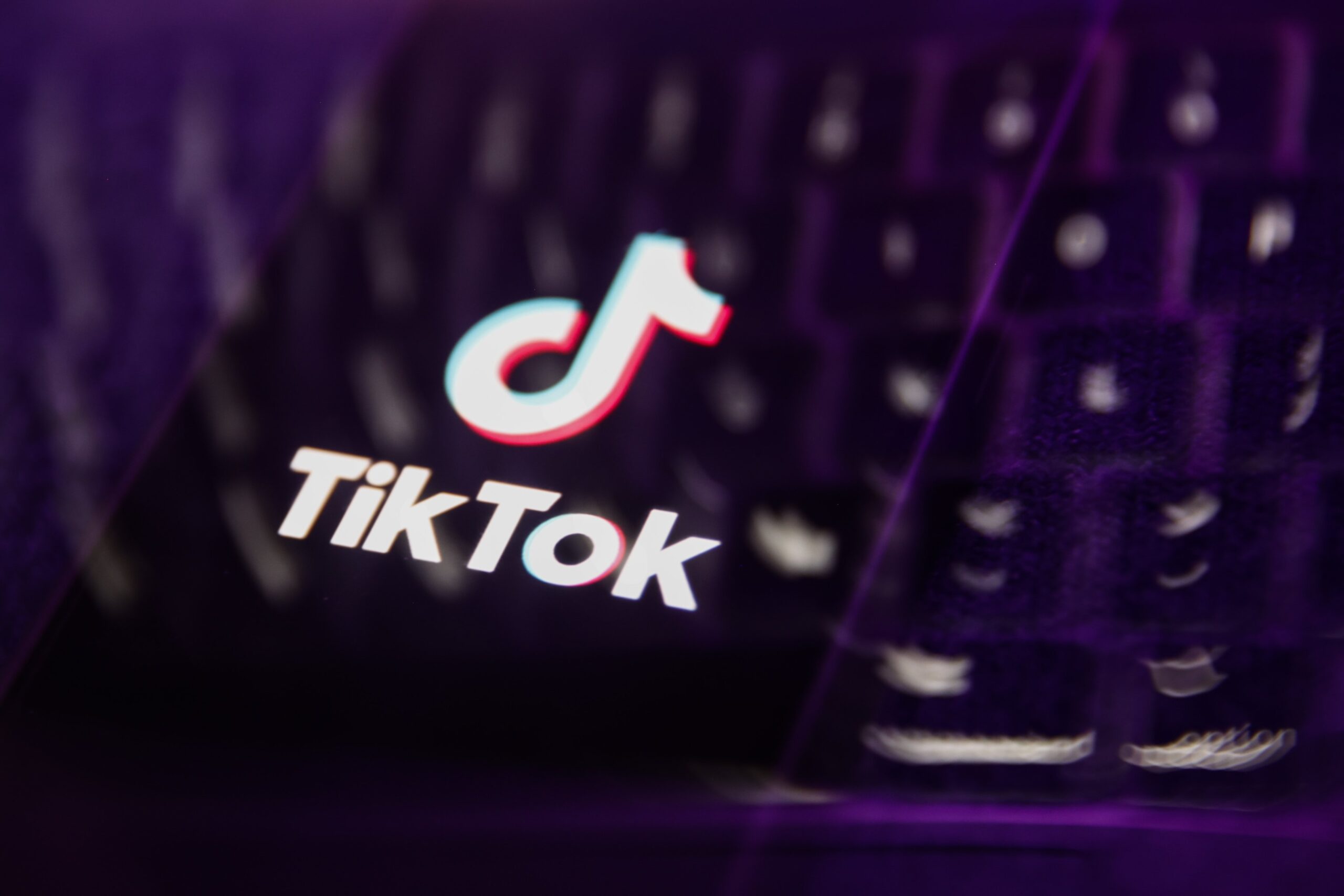 A distorted TikTok logo overlaid on a keyboard.