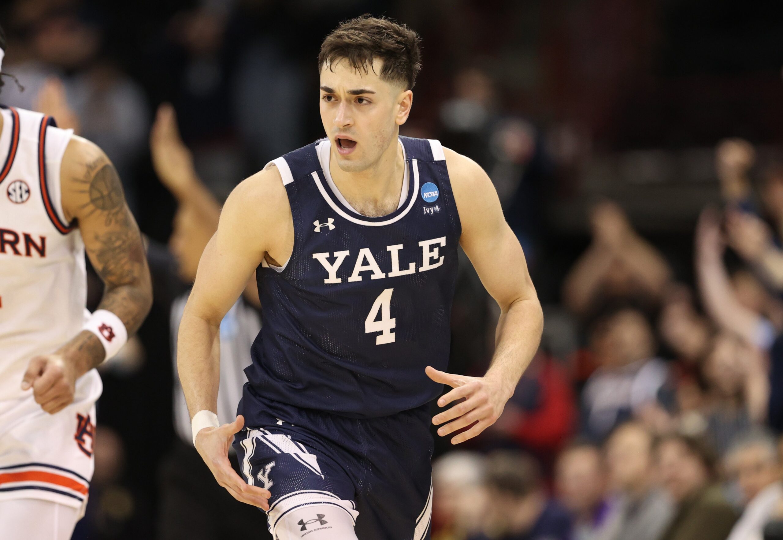 John Poulakidas #4 of the Yale Bulldogs reacts after a three-point basket during the second half against the Auburn Tigers in the first round of the NCAA Men's Basketball Tournament at Spokane Veterans Memorial Arena on March 22, 2024, in Spokane, Washington.