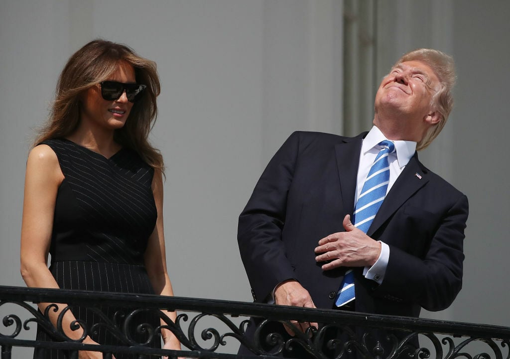 President Donald Trump squinting at the partially eclipsed sun