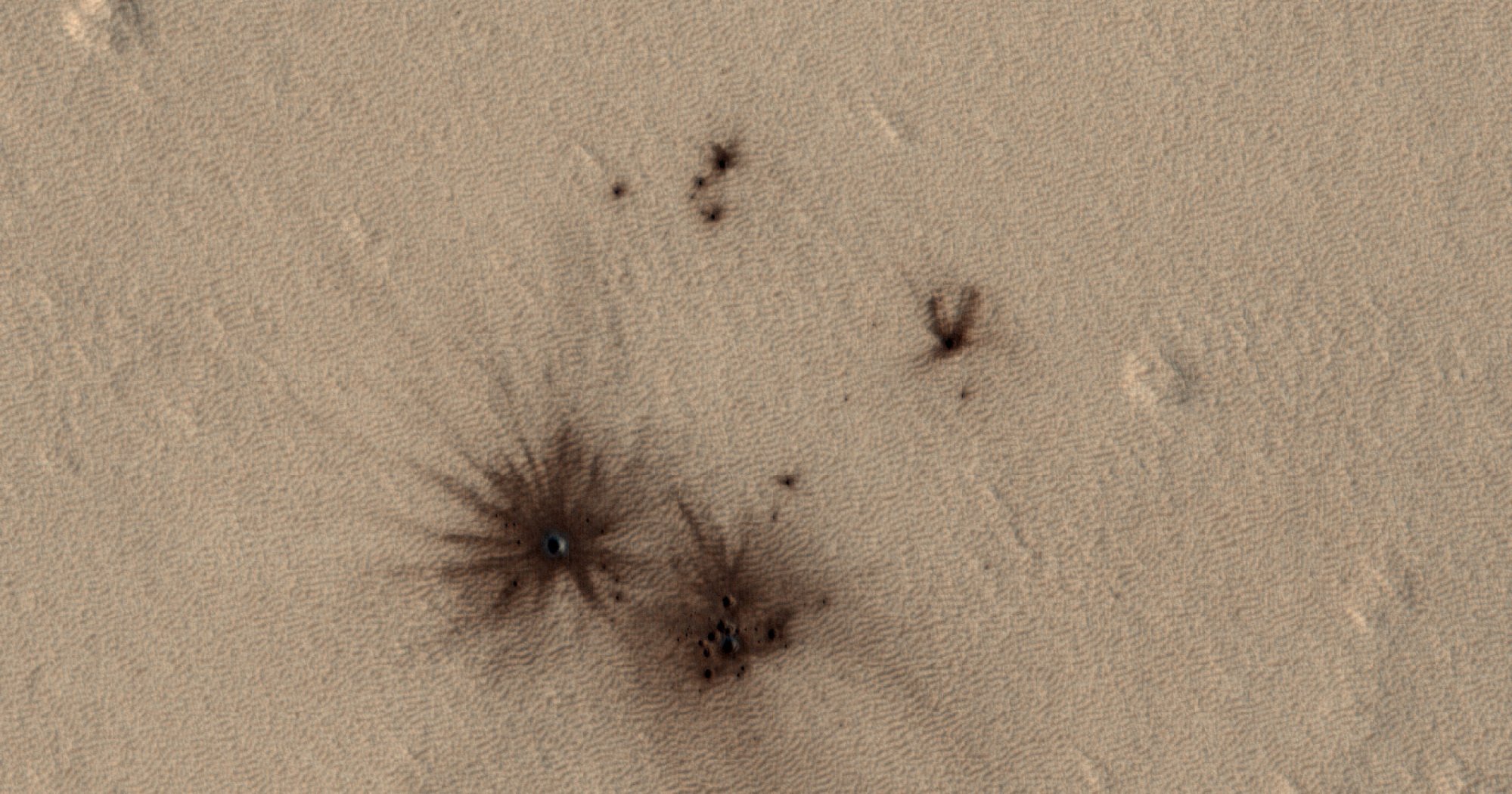 A scattering of impact sites recently captured by NASA's Mars Reconnaissance Orbiter.