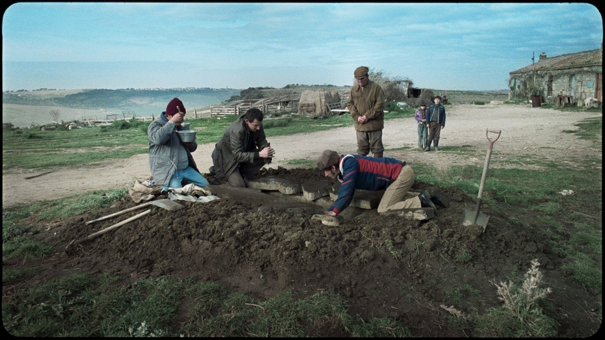 Three tomb raiders dig up a tomb along a small dirt path.