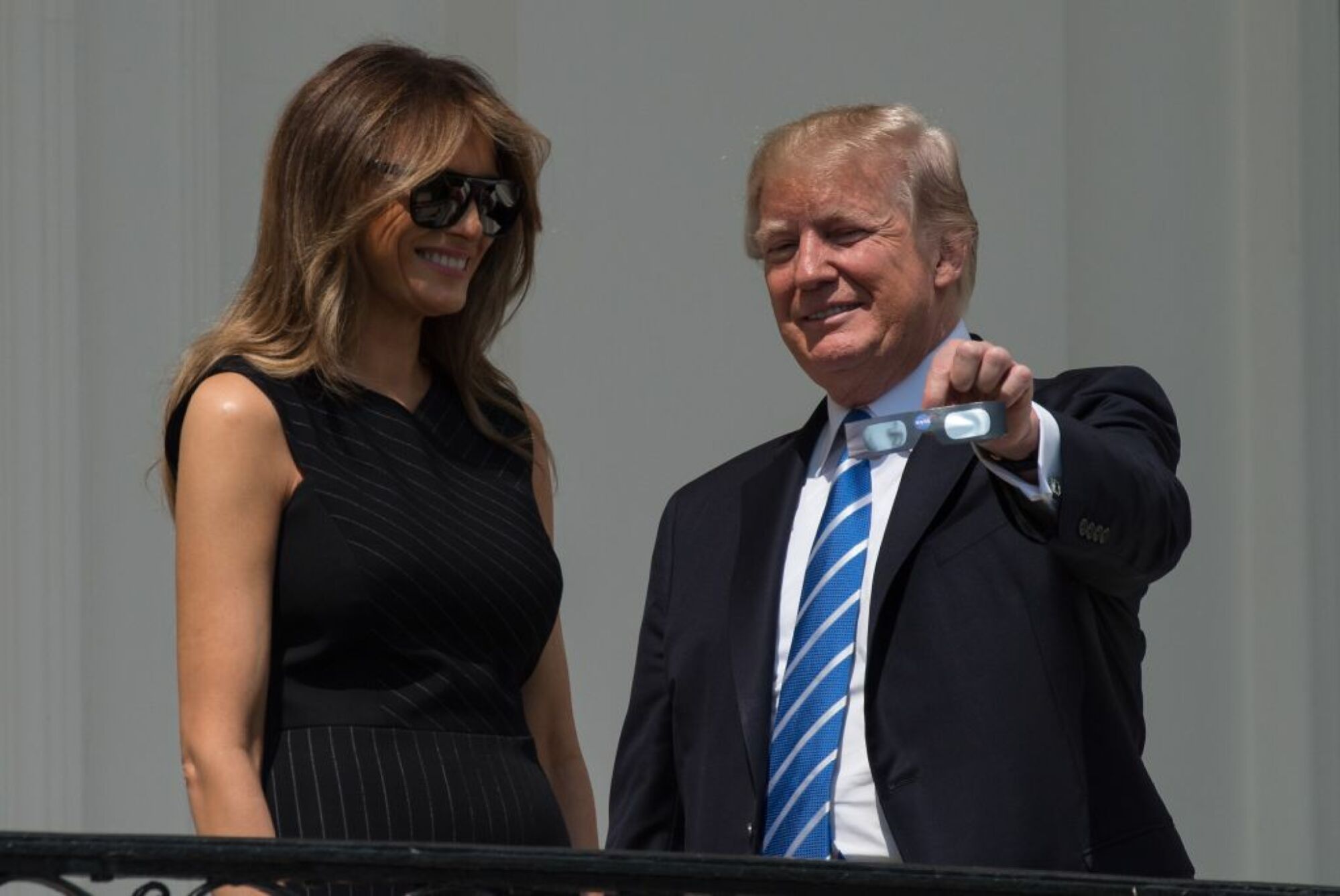 President Donald Trump holding up his eclipse glasses