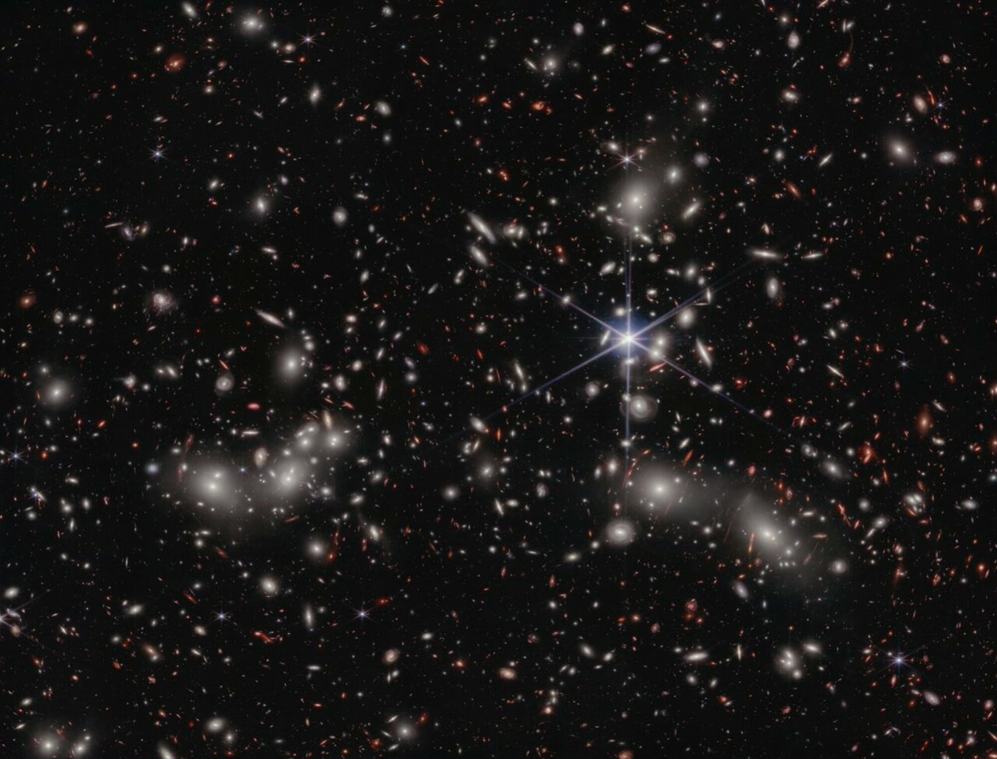 Pandora's Cluster producing a lens, called a "gravitational lens," in front of distant galaxies.
