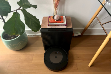 Roomba Combo j9+ robot vacuum and dock with books and vase as decor on top and plant in peripheral