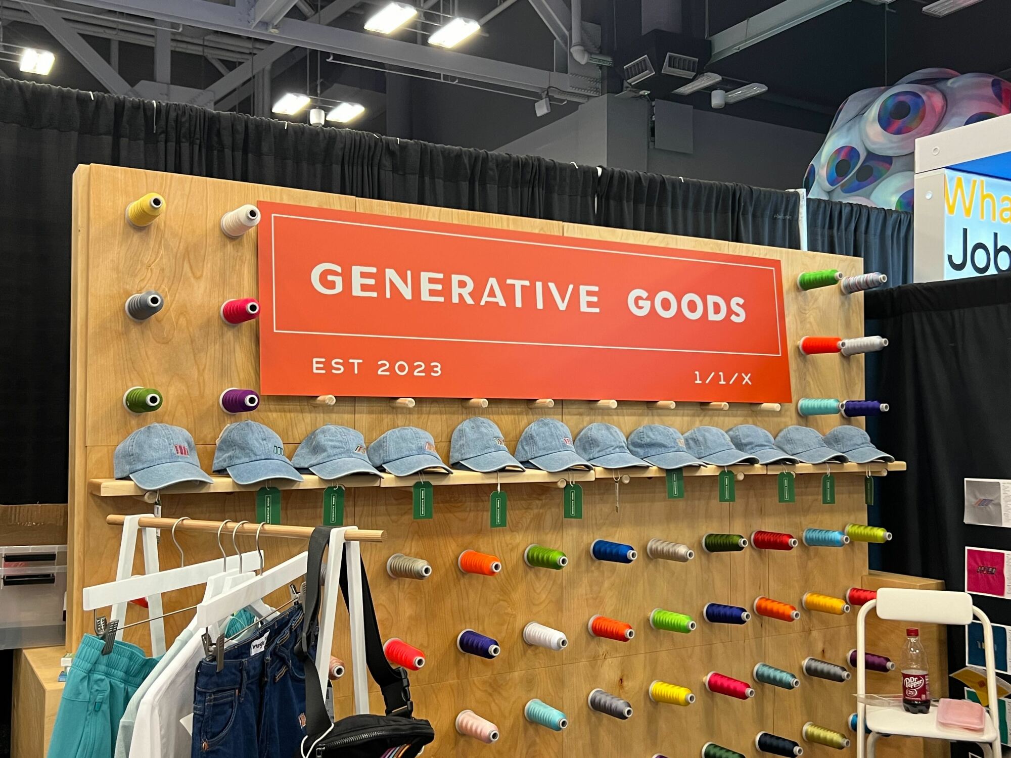 a display of hats and yarn across a wooden board with a orange sign that says "generative goods"