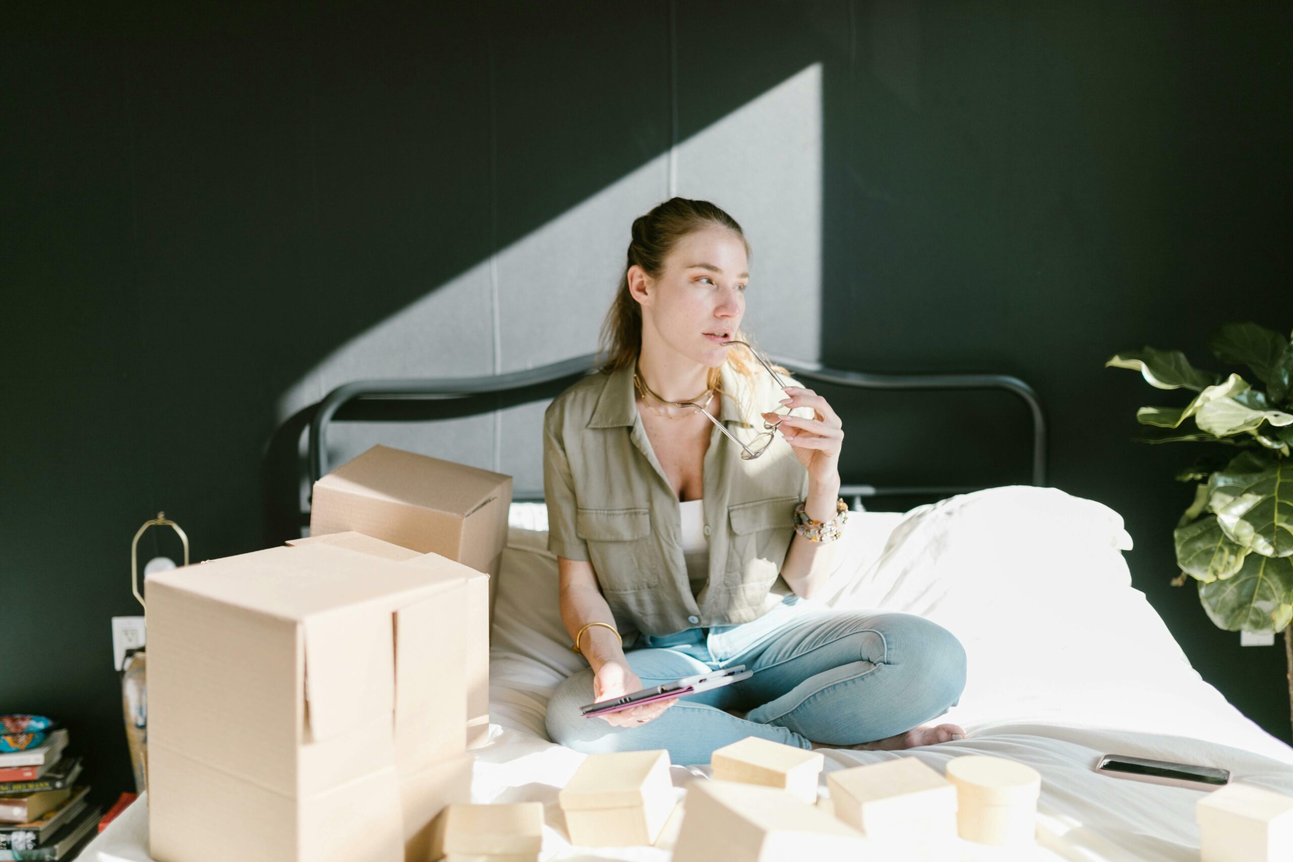 Woman surrounded by boxes on bed