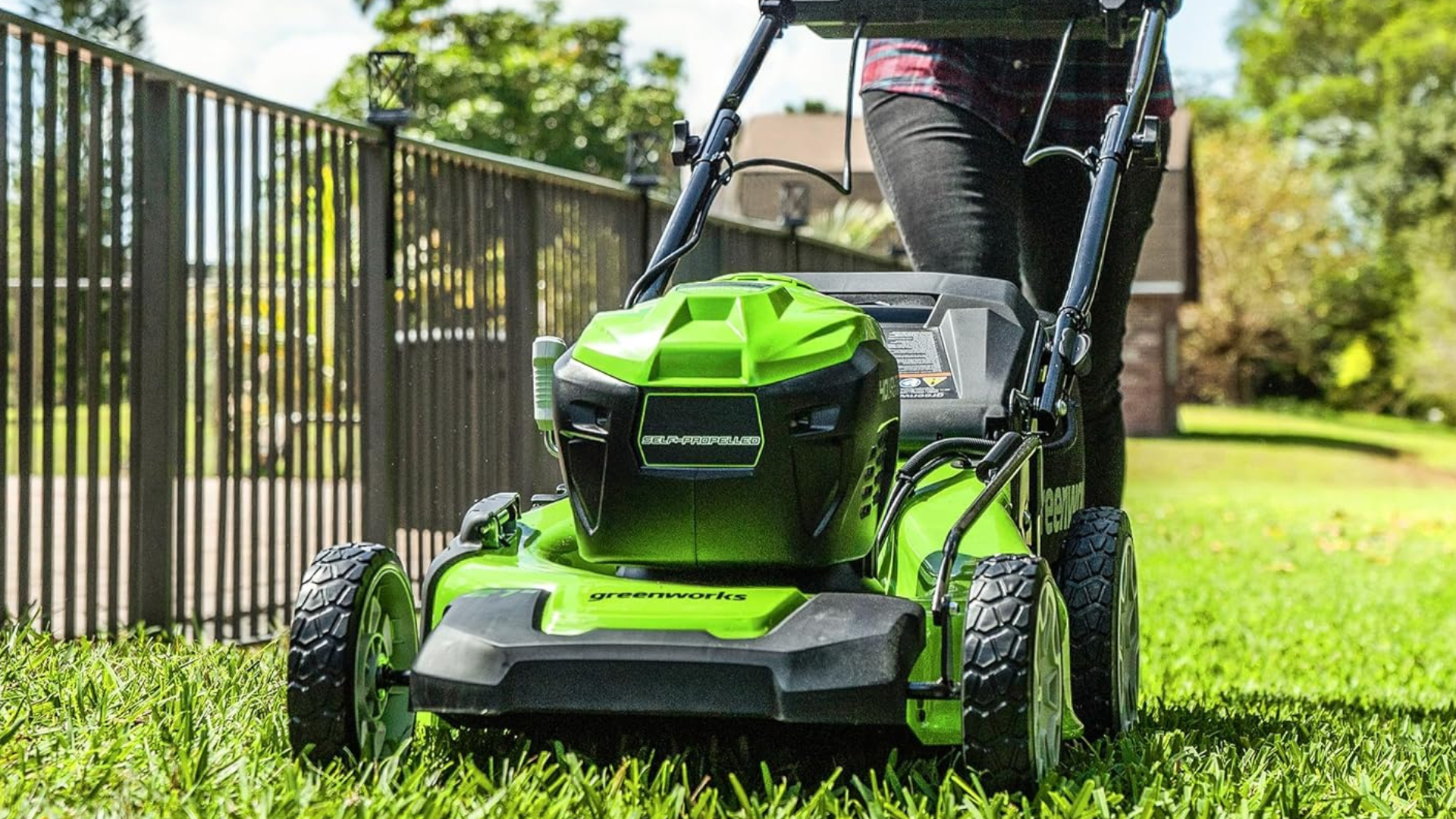 A person pushing a Greenworks mower