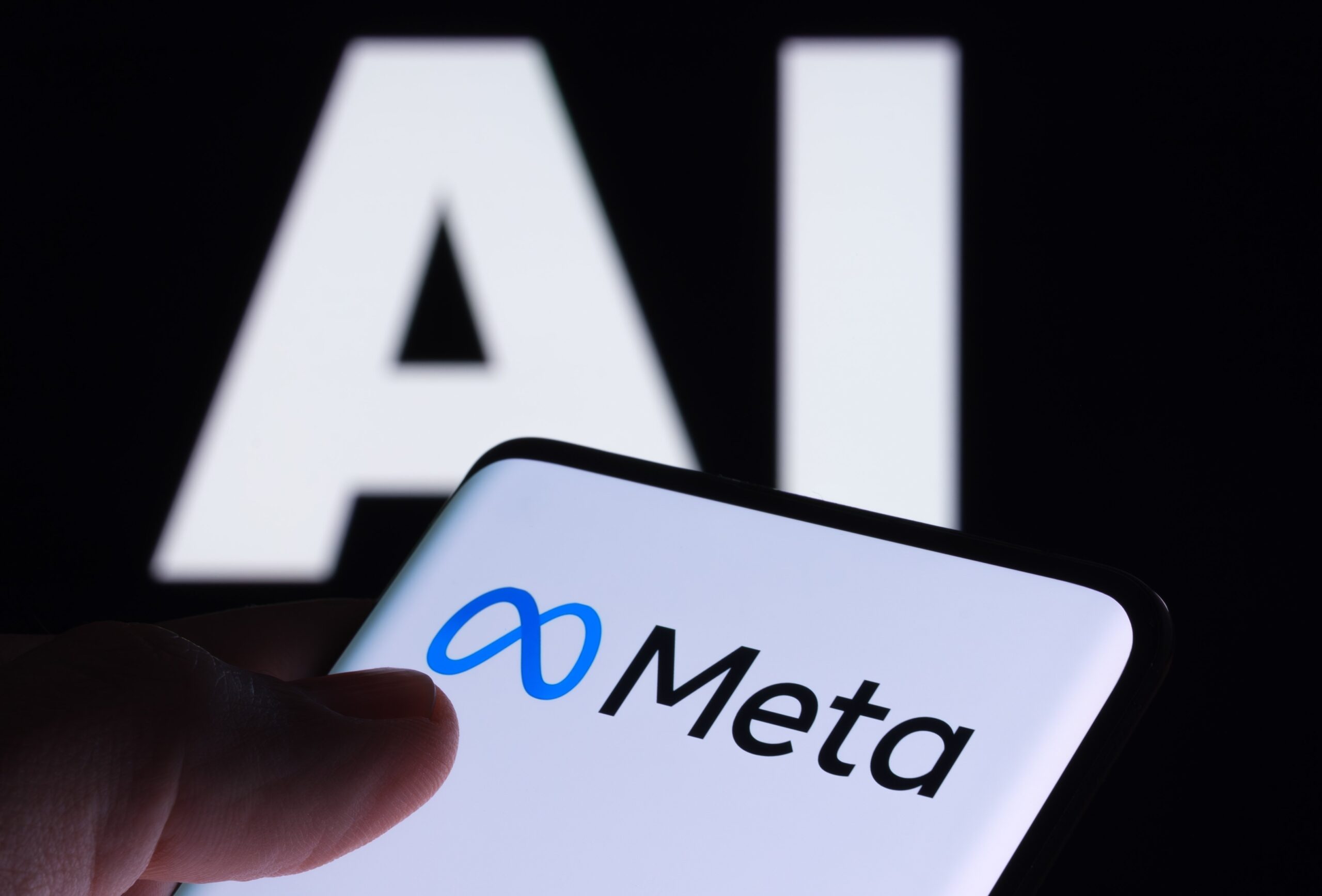 Meta logo on a smartphone in front of a background that reads AI 