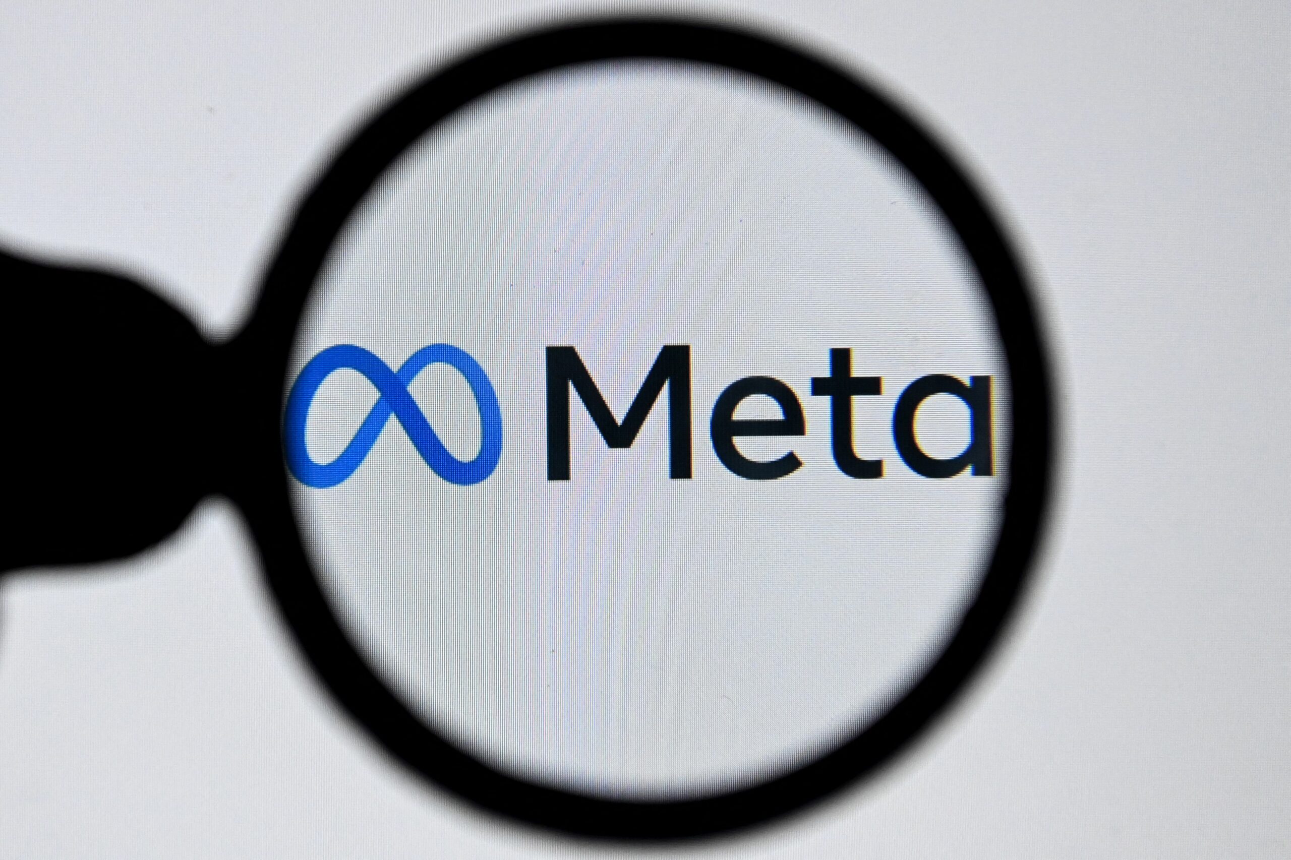meta logo seen through a magnifying glass
