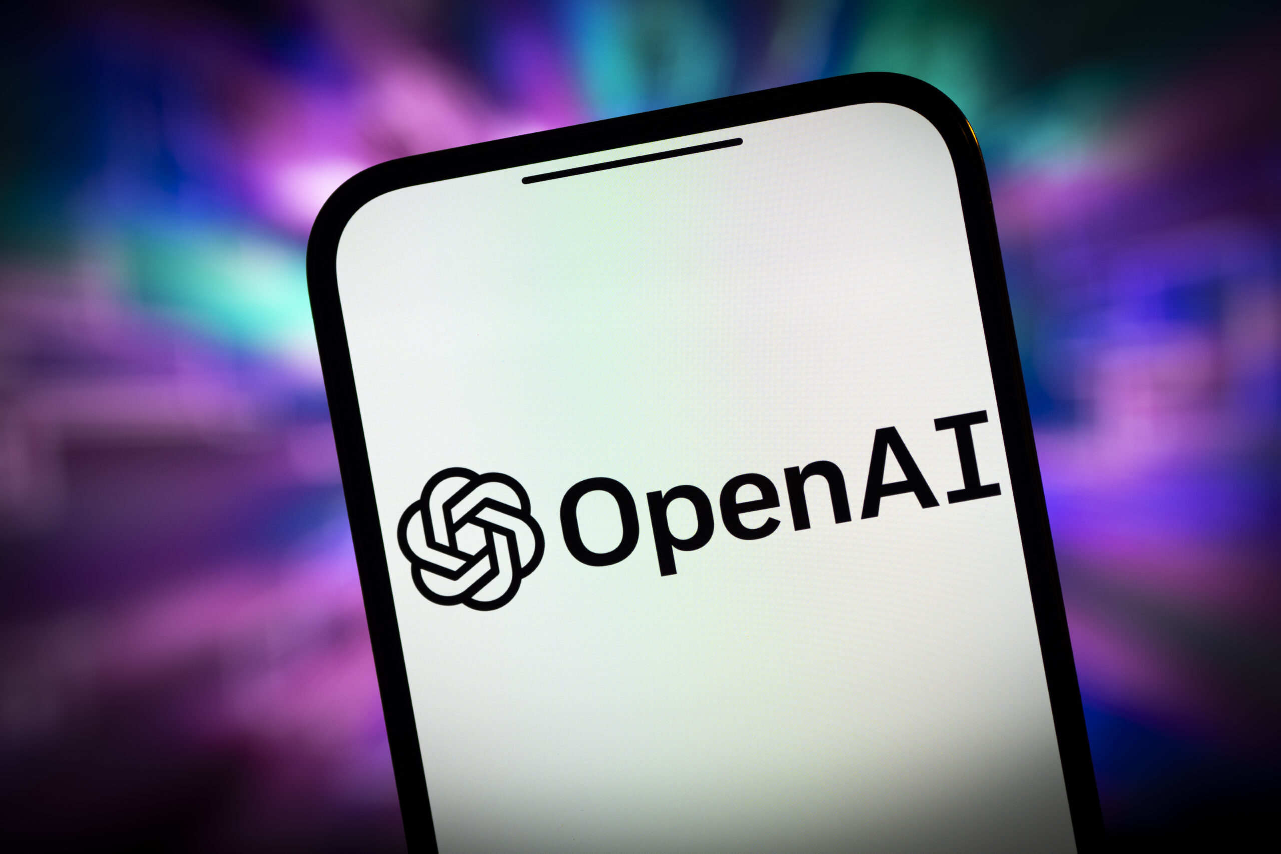 openai logo on iphone in front of colorful background