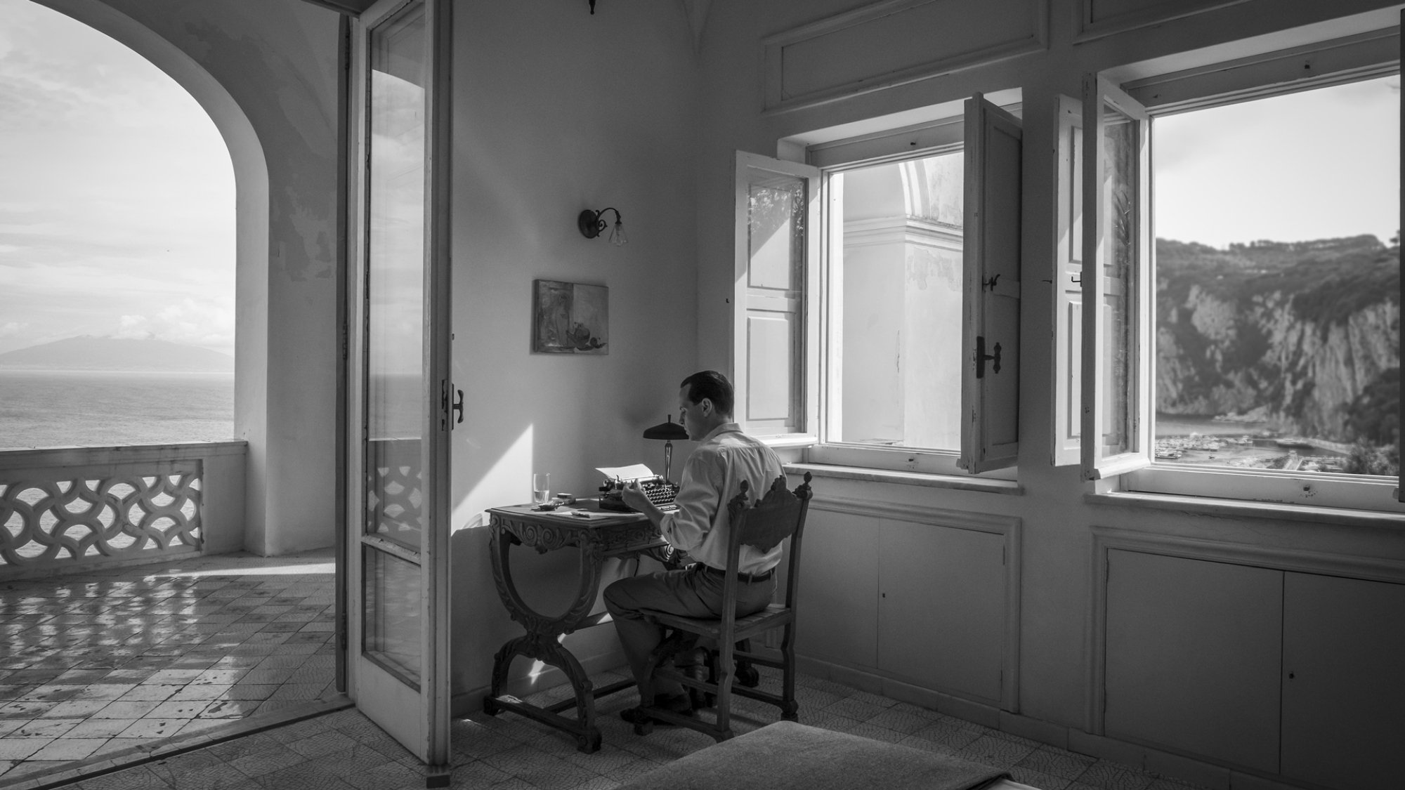 A man types a letter in a villa.