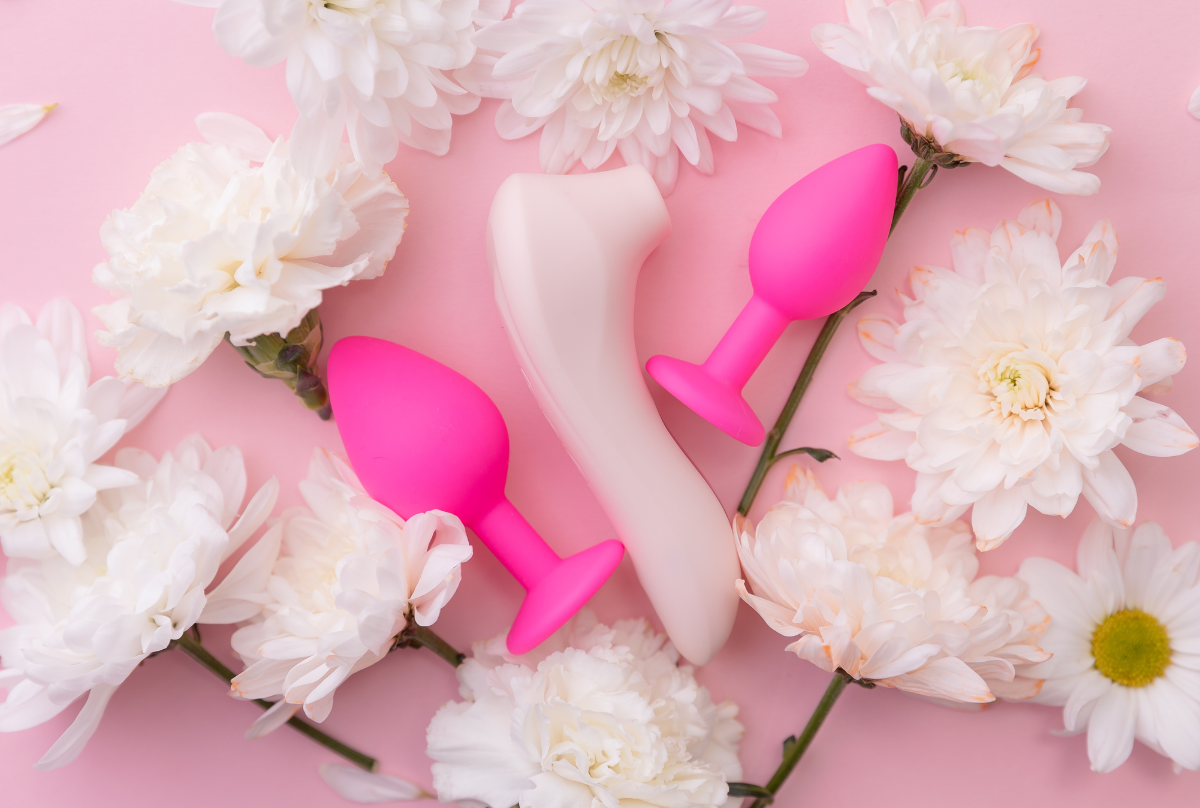flat lay of sex toys with flowers 