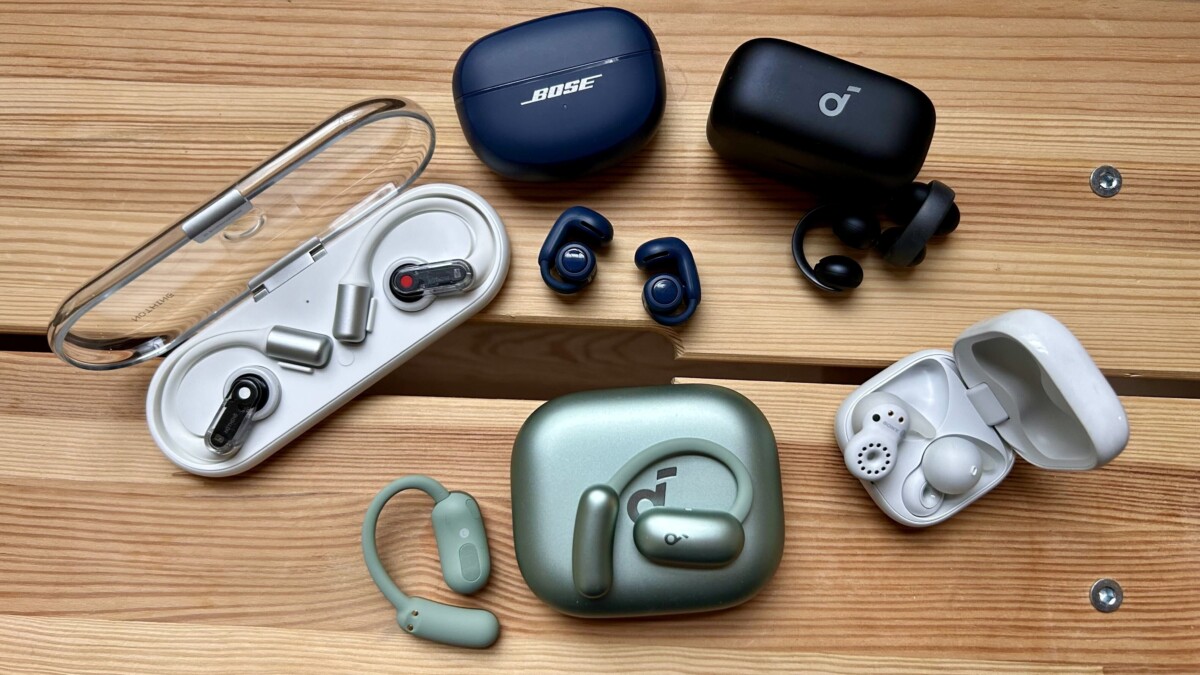 open earbuds in cases open on wooden bench