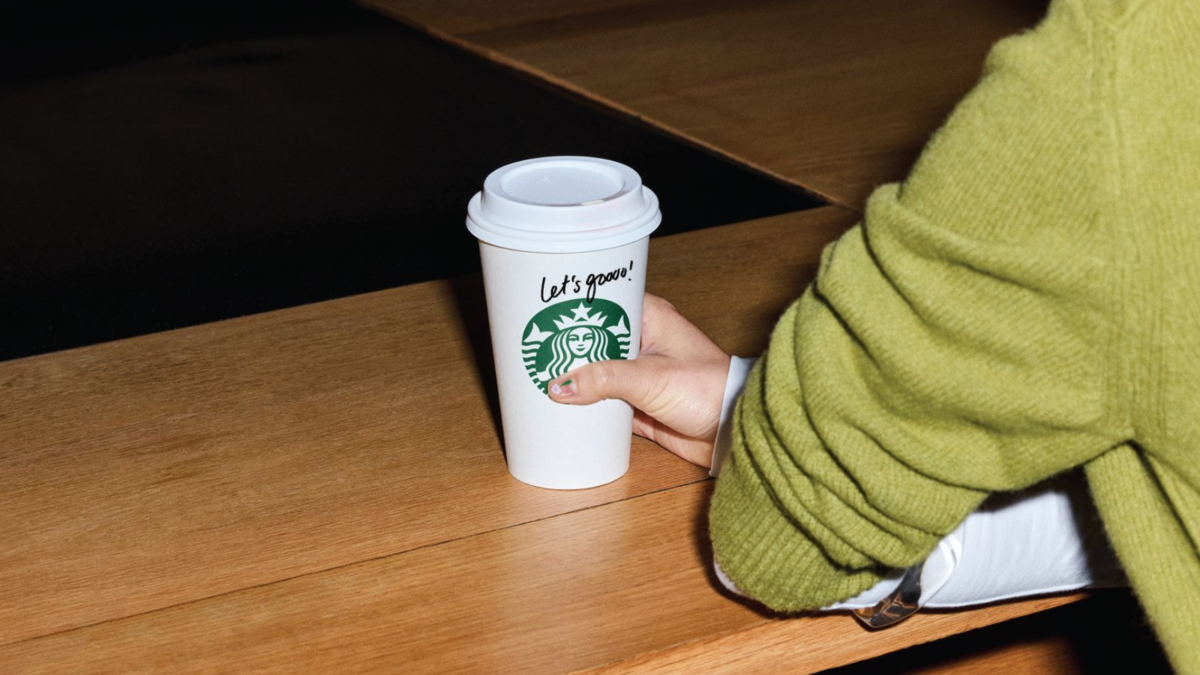 a close-up of a person holding a starbucks cup