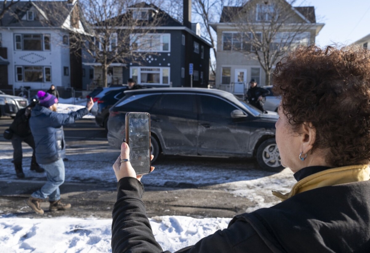 A woman filming a man flipping the bird to ICE agents. 