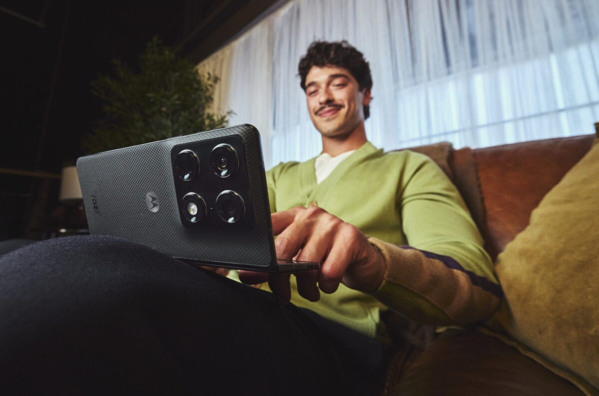 man using motorola razr fold on couch